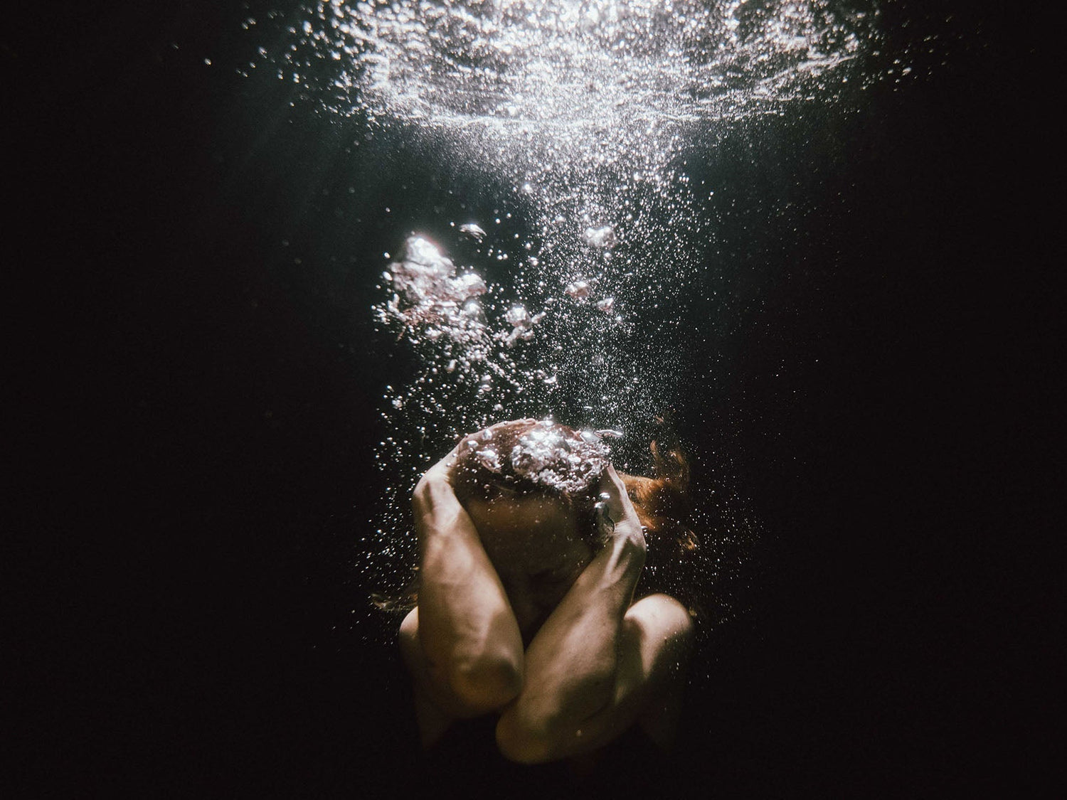 Underwater model with light rays and bubbles image by Alison Bounce for her REBORN underwater documentary about Endometriosis